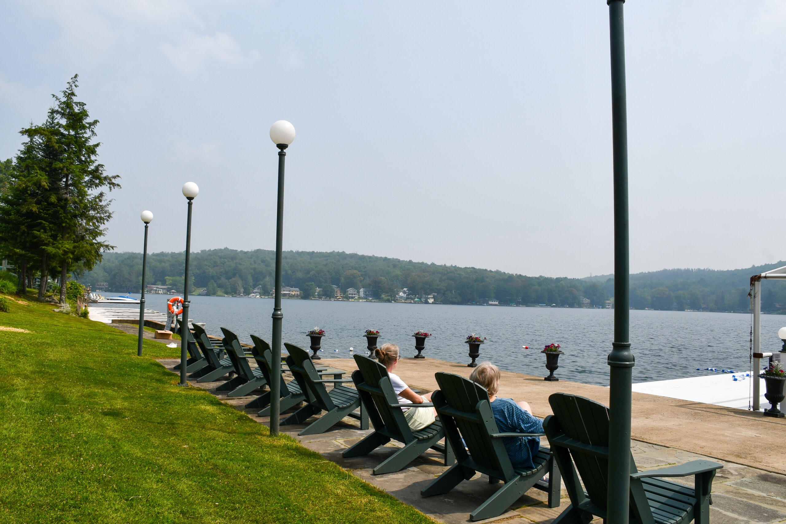 Adirondack chairs on a dock by the lake