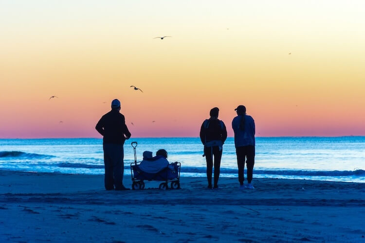 family on virginia beach looking at the sunset