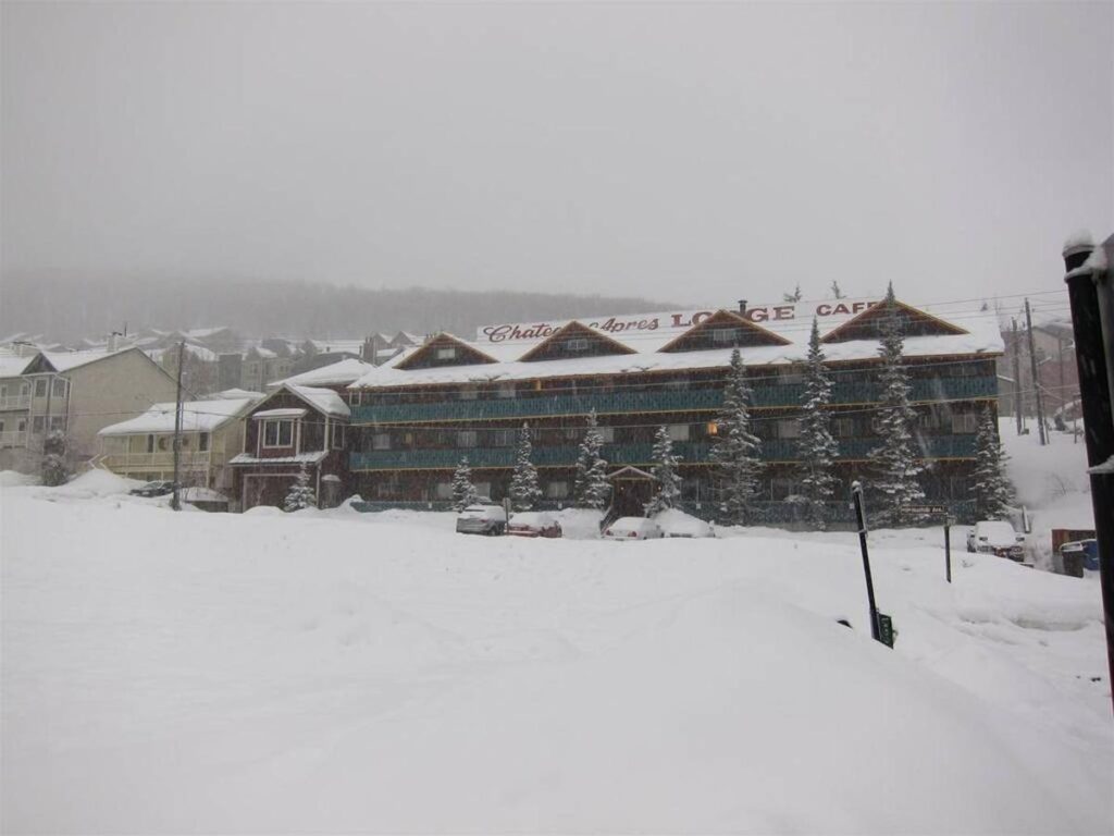 Wide shot of lodge exterior in heavy snowfall