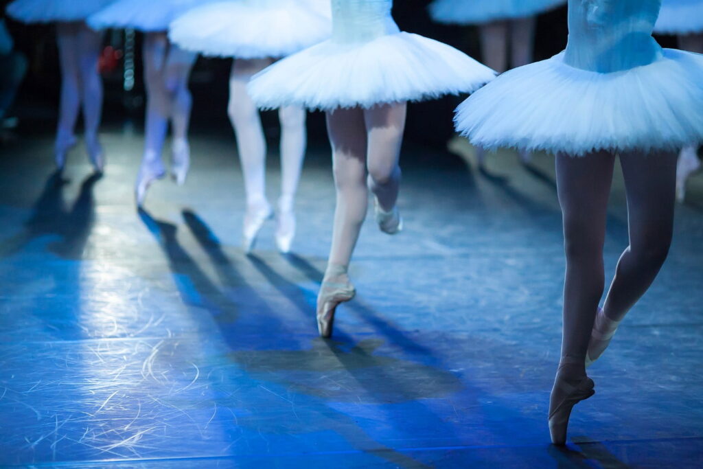 Ballet statement. Ballerinas in the movement. Feet of ballerinas close up.