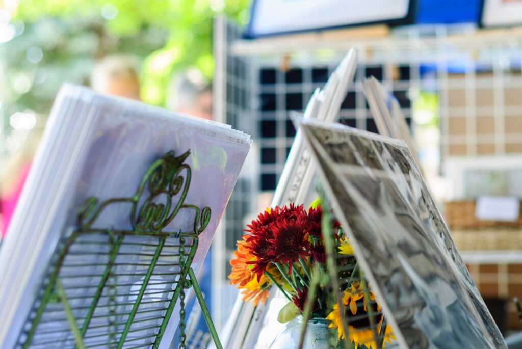A display of photographs and flowers in a vase at the Livermore Artwalk.