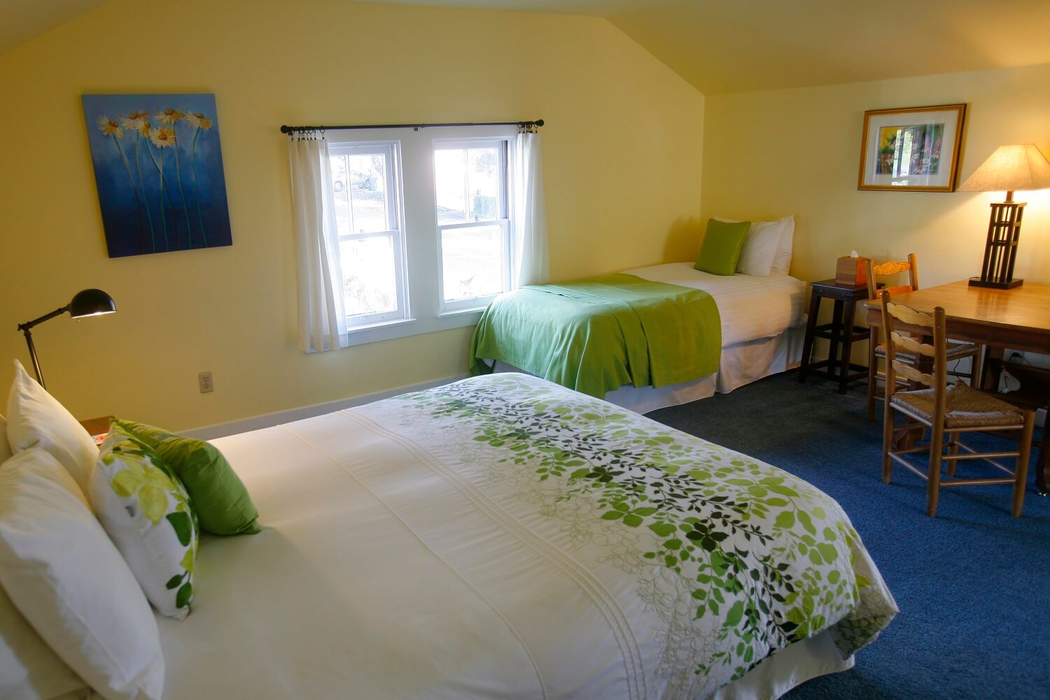Aloft room view of queen and twin beds with table, chairs and nightstands