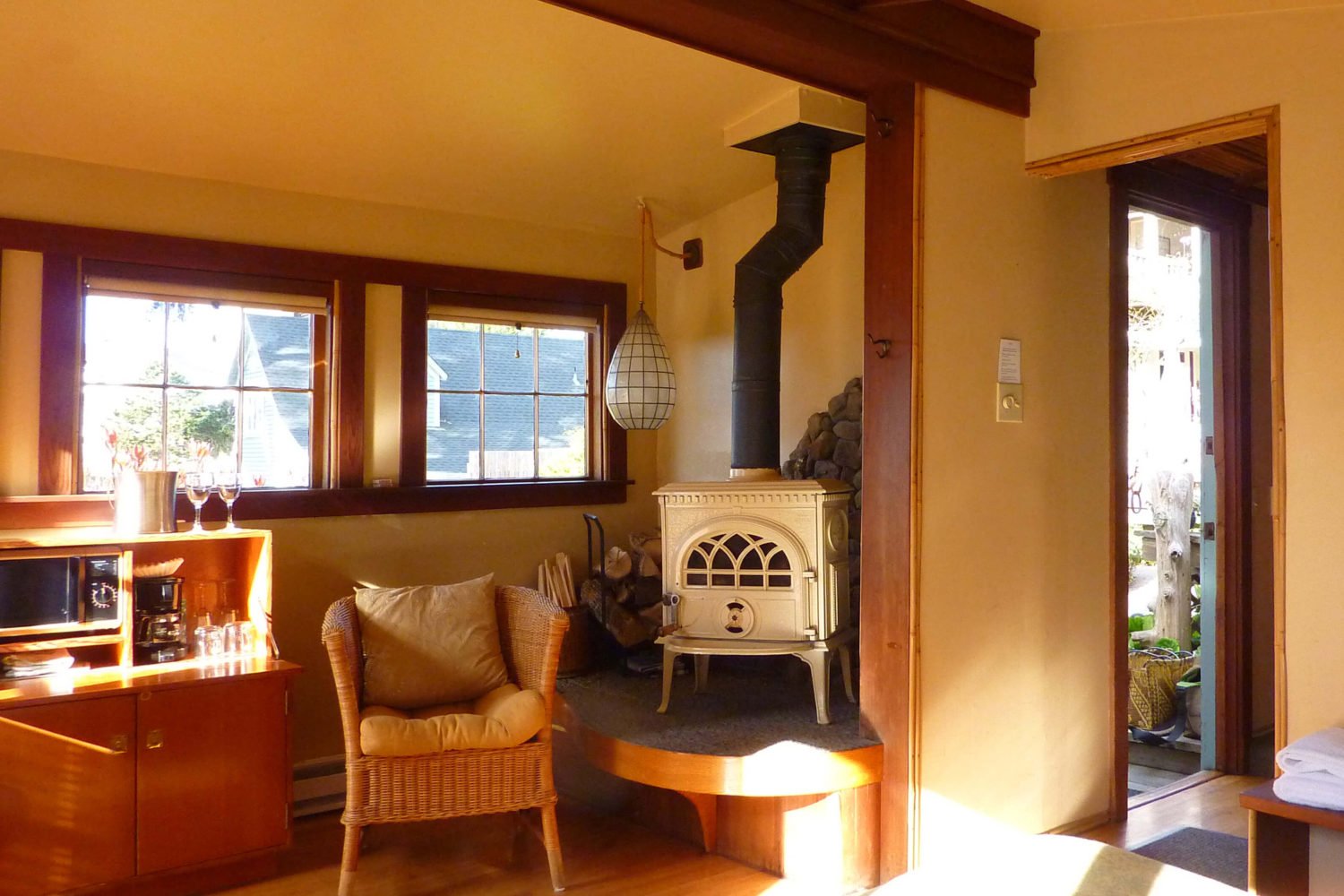 Cove room - view of stove, chair, bar, square windows and door