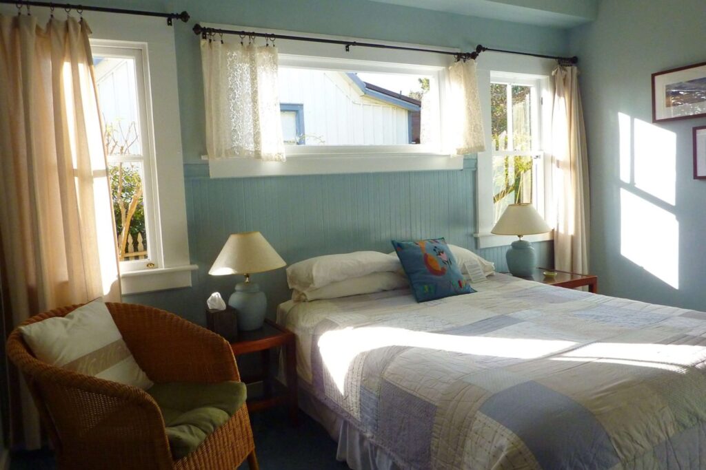 West room bed, chair, nightstands, and wicker chair