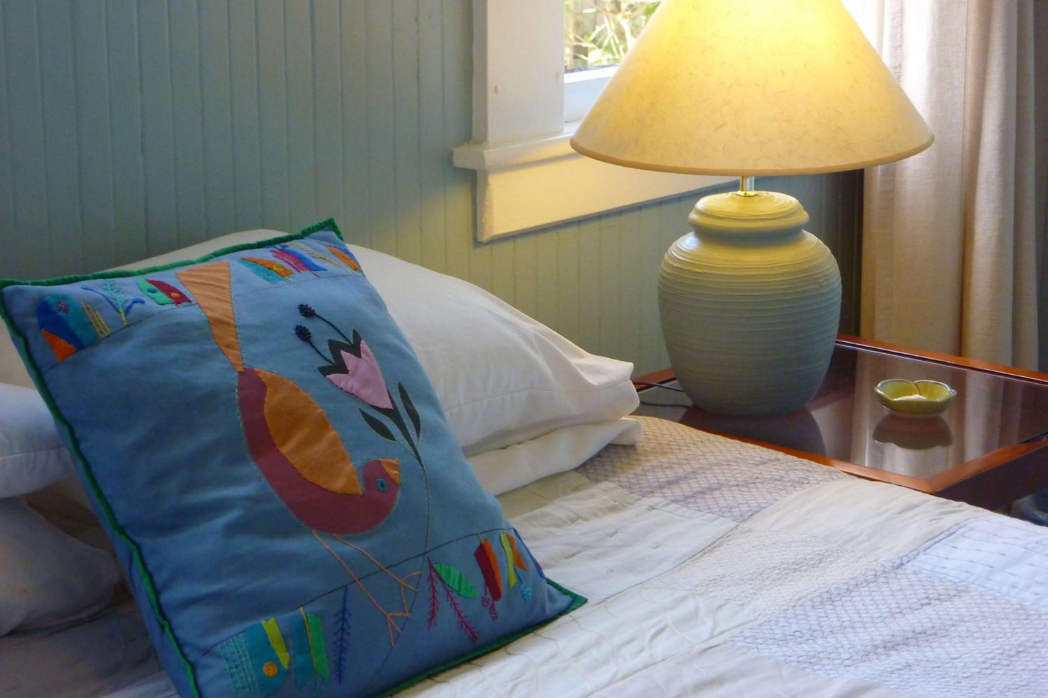 West Room Pillow, bed, nightstand and lamp close-up