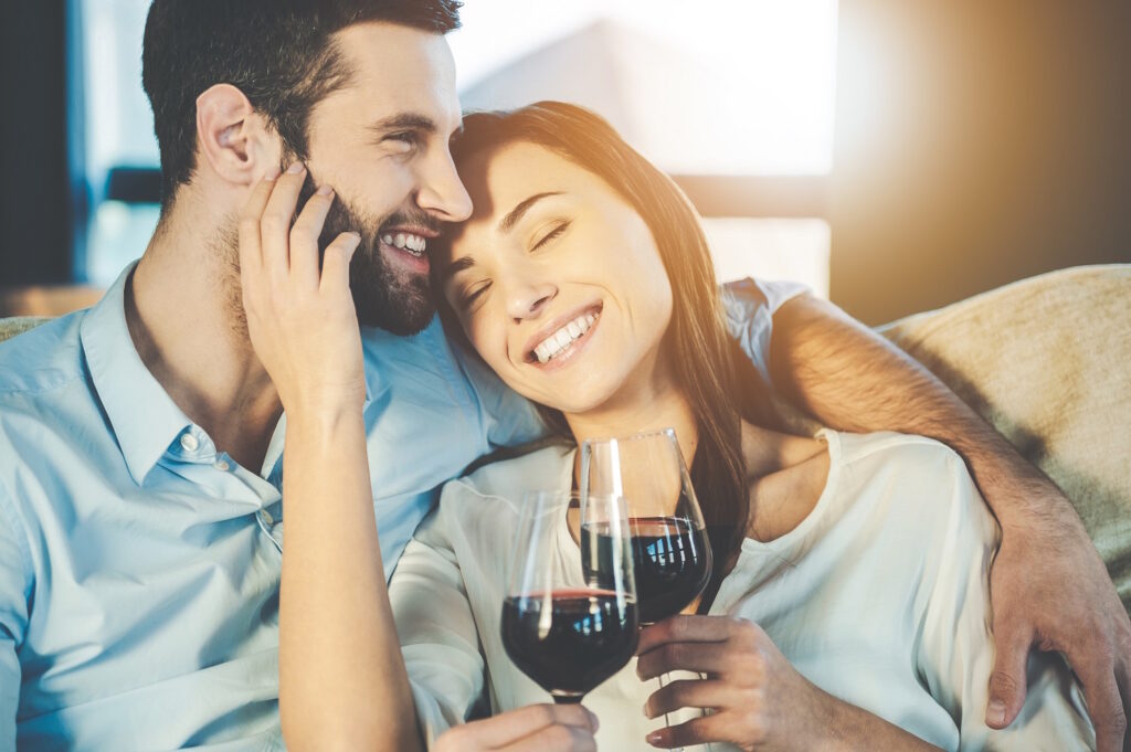 Man and woman each holding glass of red wine