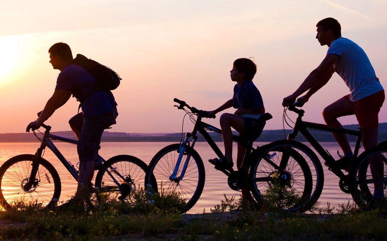 family riding their bikes at sunset