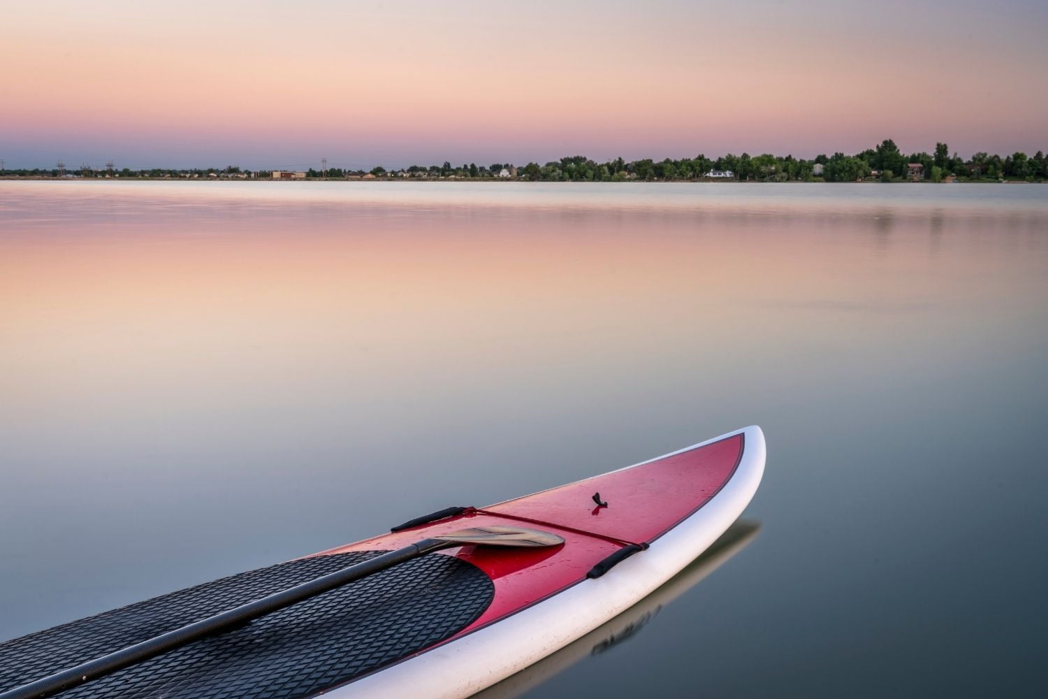 Paddleboard on a lake at sunset.
