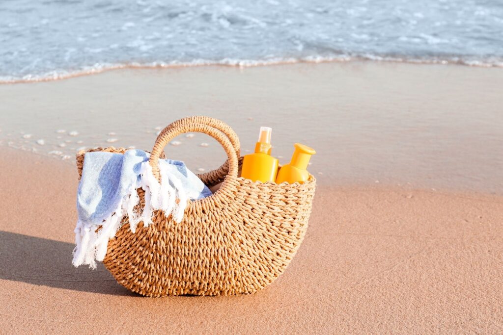 bag on beach with towel sunscreen and lotion in it