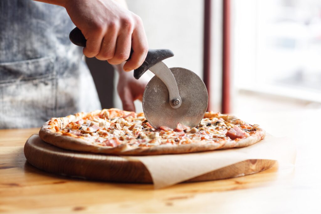 Chef cutting the best pizza amelia island for guests to enjoy