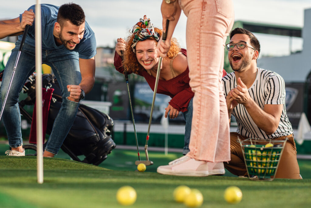 Group of friends enjoying together playing mini golf in Fernandina Beach.