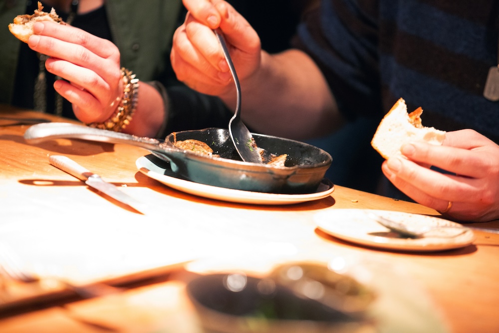 Fancy dinner with people eating from bowl with sandwiches in hand
