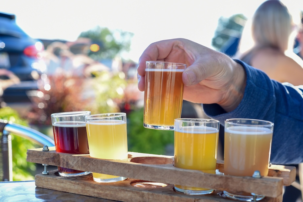 Man sampling a variety of seasonal craft beer at an outdoor beer garden, 