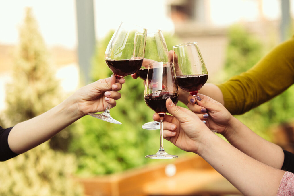 People clinking glasses with wine on the summer terrace food and wine festival