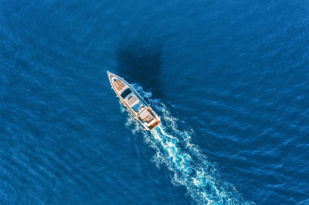Aerial view of boat sailing in blue waters