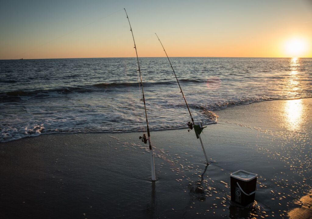 Fishing poles on beach at sunset