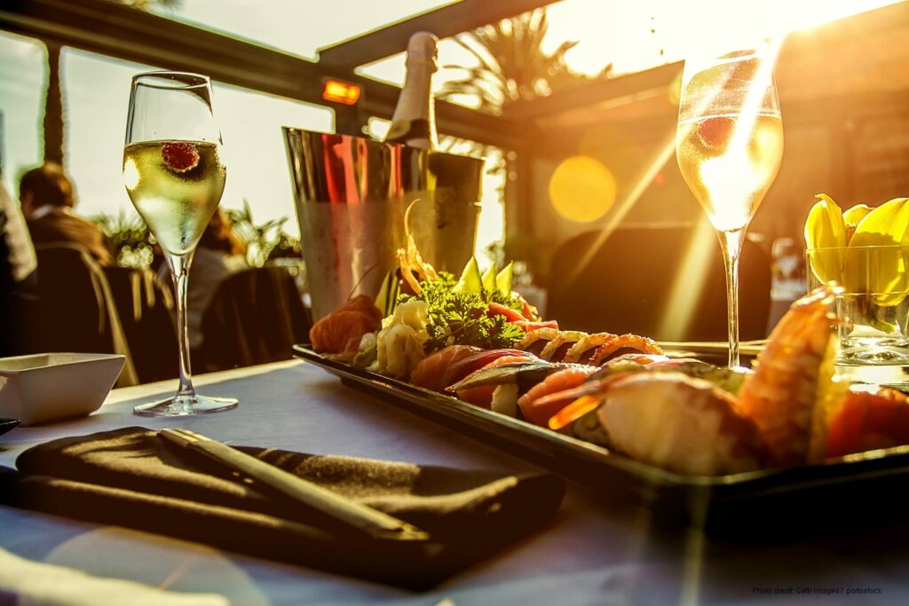 Luxury restaurant table with sushi dish , champagne and the sunset