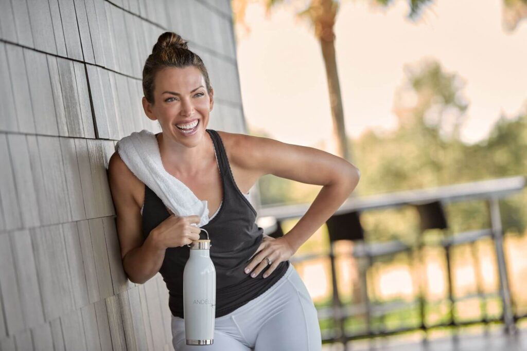 Woman with Water Bottle Smiling After Workout