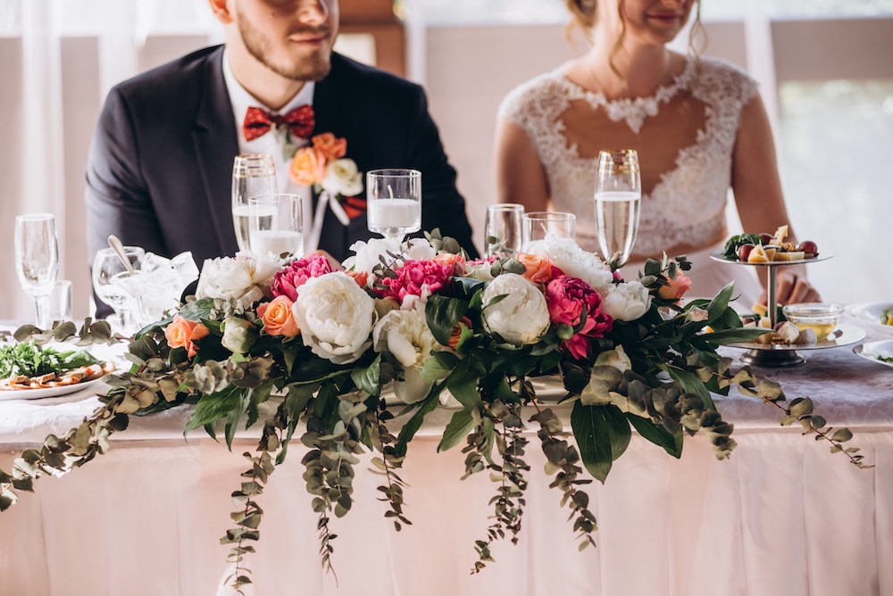 Bride and groom at head table of wedding reception