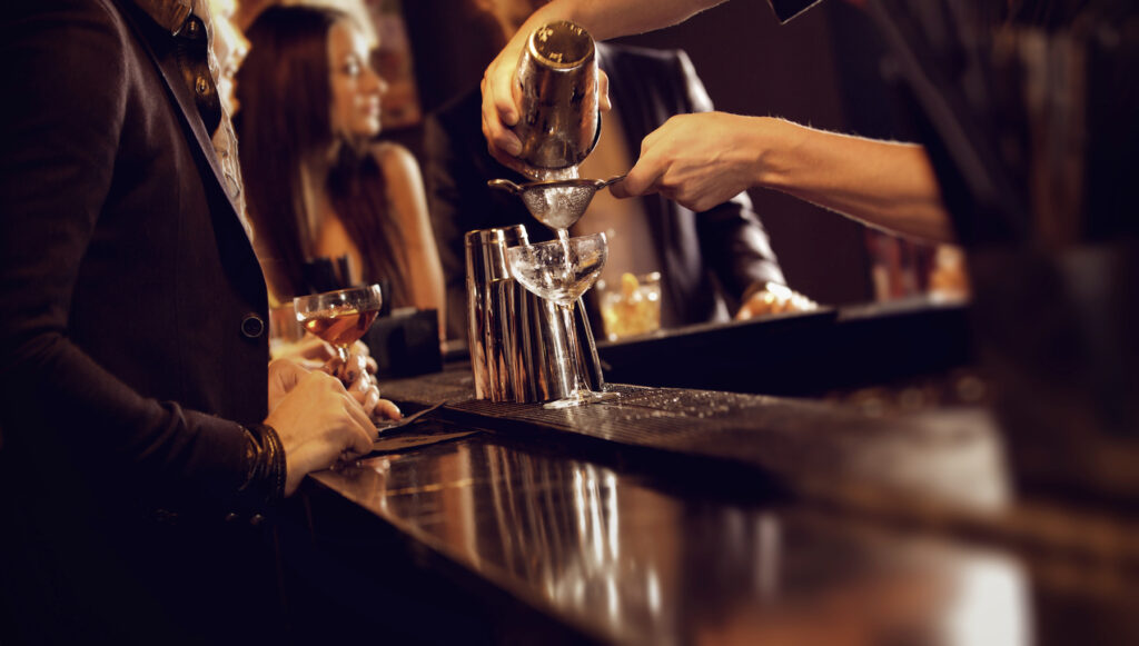 Bartender shaking a martini at a bar - Bartender Making a Cocktail Drink