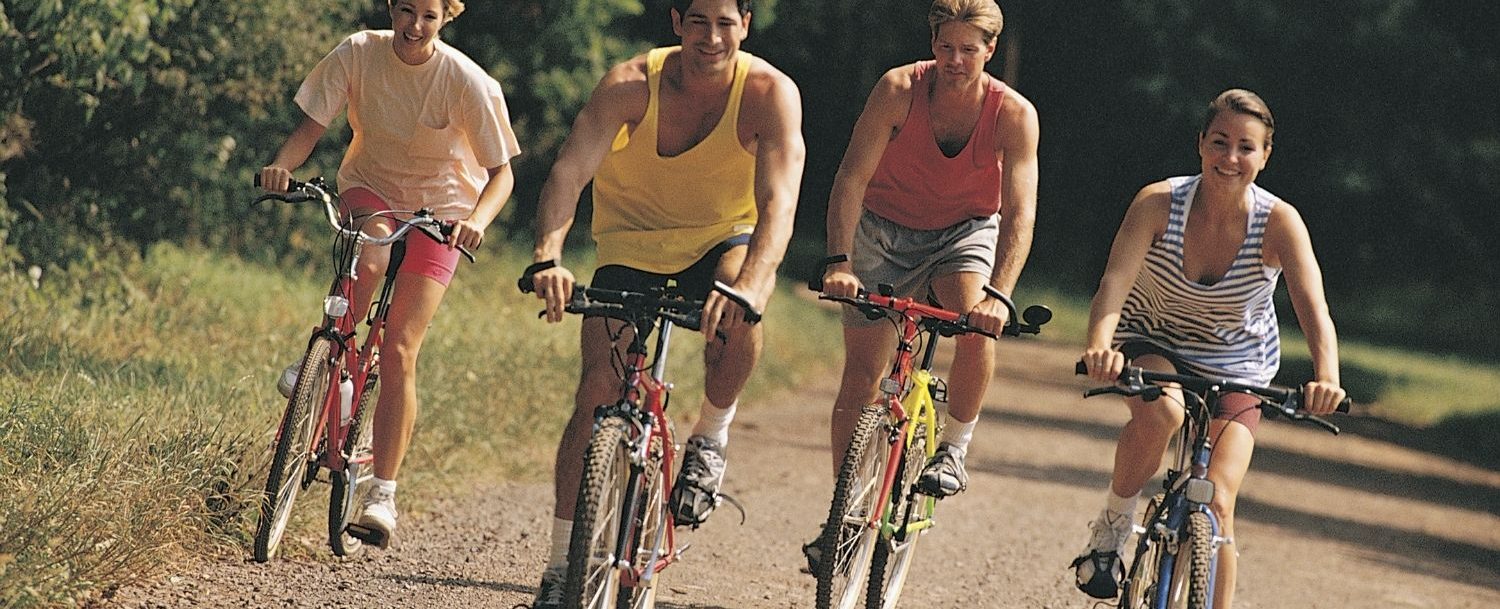 Four people riding bikes next to each other