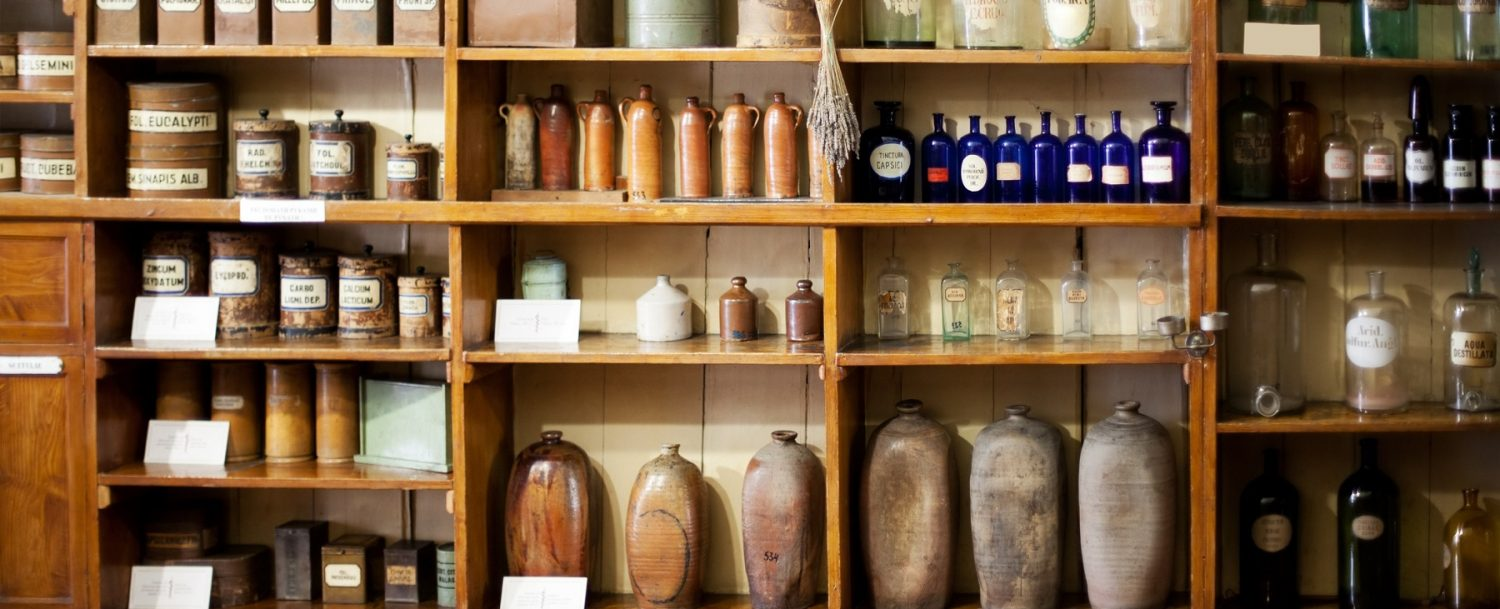Various pottery and glass bottles sitting on old shelves