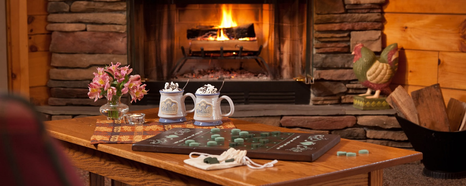 Fireplace with hot chocolate and board game on table in front of it
