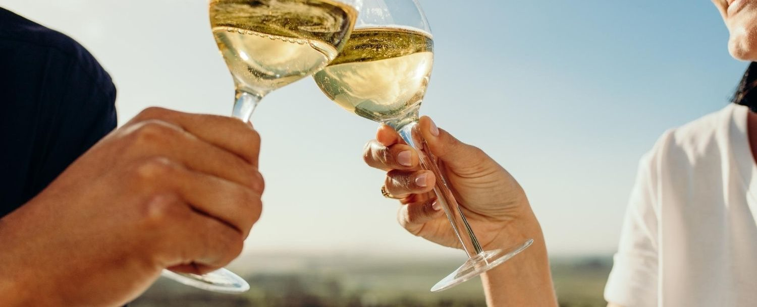 Couple toasting glasses of white wine