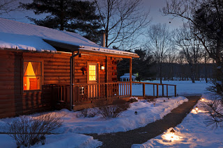White Oak Inn log cabin exterior at night during winter with snow