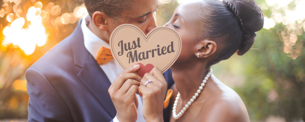 couple kissing with just married sign