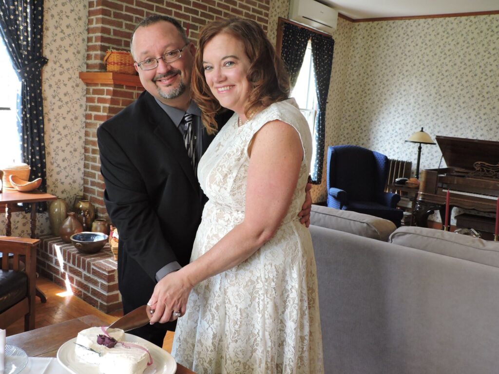 wedding couple indoors cutting cake at bed and breakfast