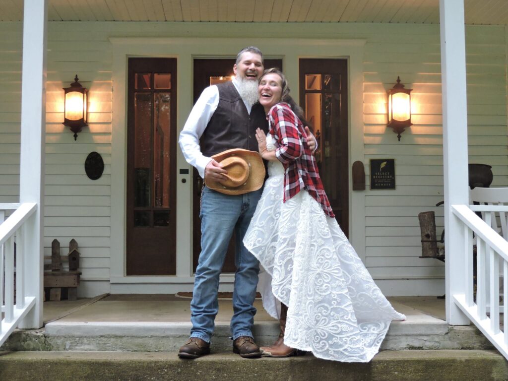 couple in western wedding attire on front porch of the white oak inn