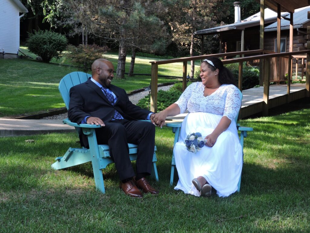 wedding couple sitting in chair on lawn at the white oak inn