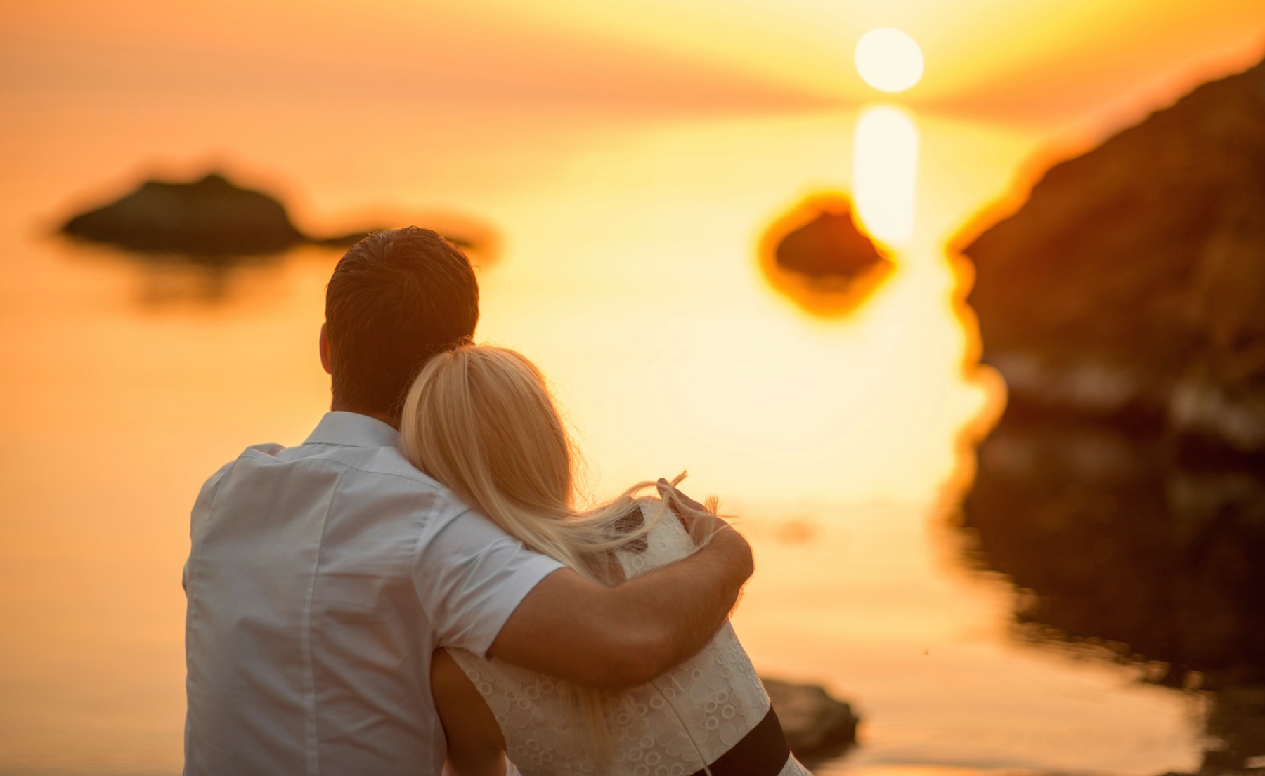 Couple watching sunset over water