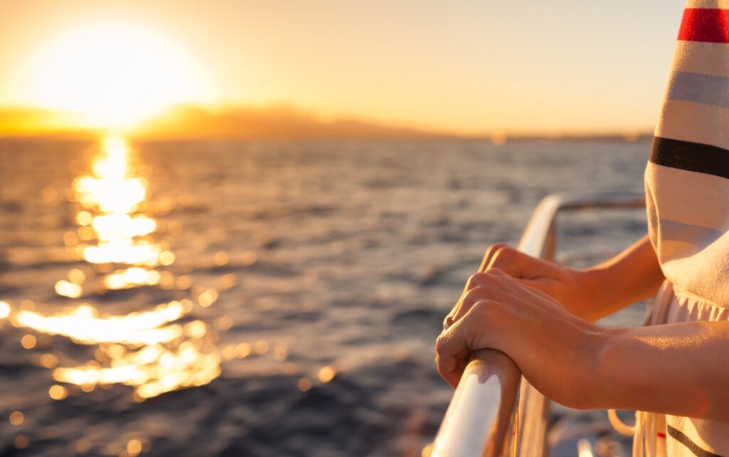 Closeup of female hands on a yacht during sunset.