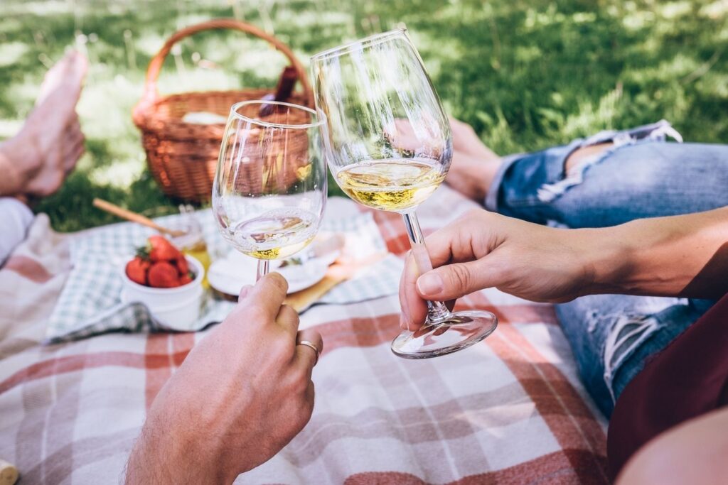 Man and woman on a picnic with food and wine.