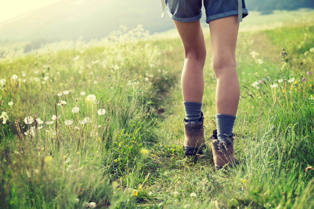 Woman hiking through grassland.