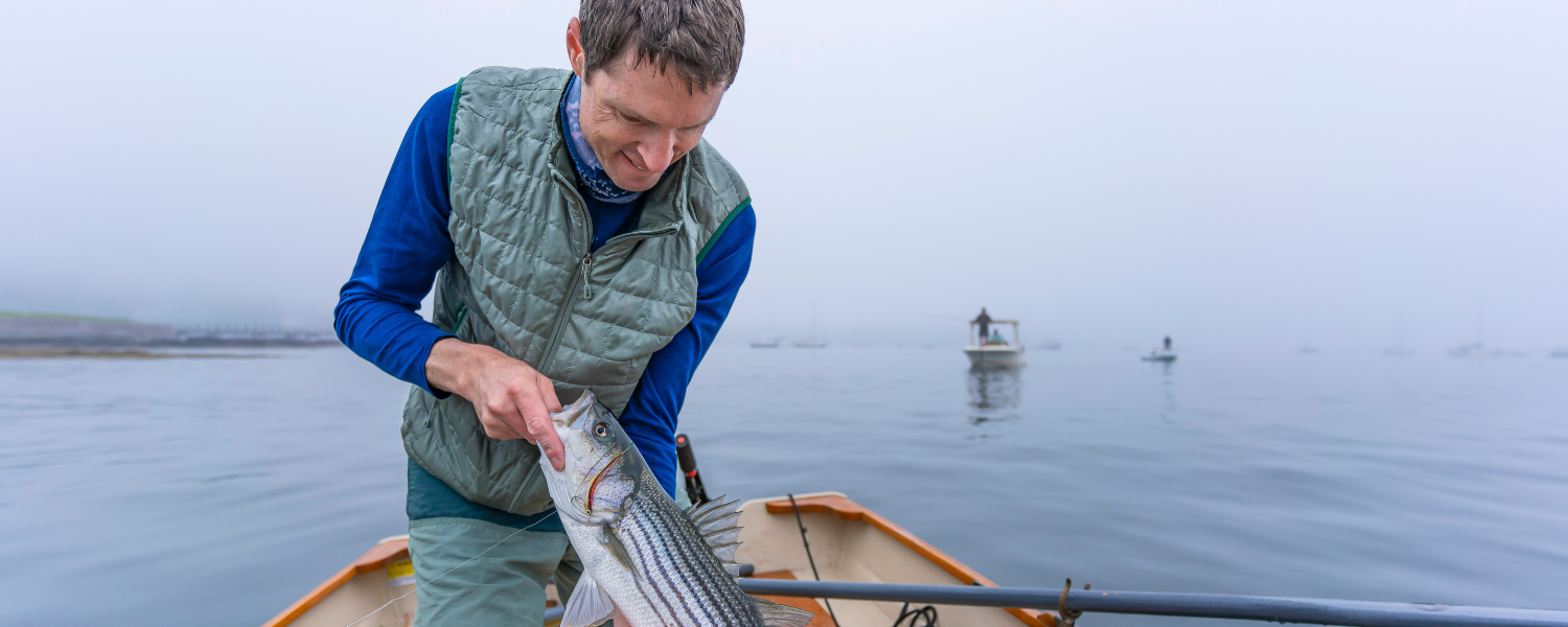 man putting a fish in his boat