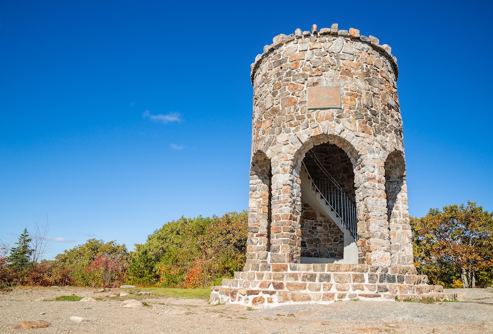 Observation tower at the peak of Mount Battie in Camden, Maine, USA. Sunny, autumn day with bright blue sky background.