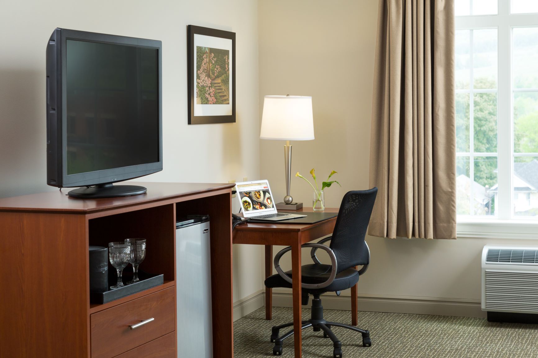 Guest Room with TV Refrigerator and desk with chair