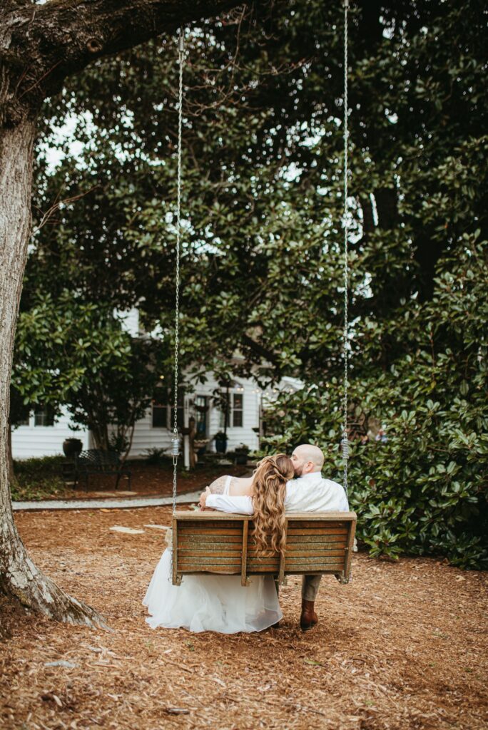 Couple Sitting on Swing Under Tree