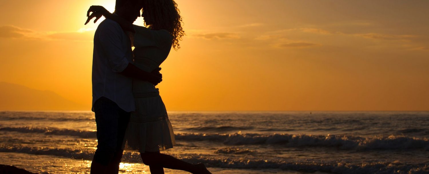 couple silhouette on beach sunset romantic getaway honeymoon