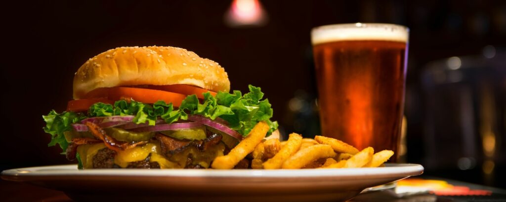 burger and fries on a table next to a beer