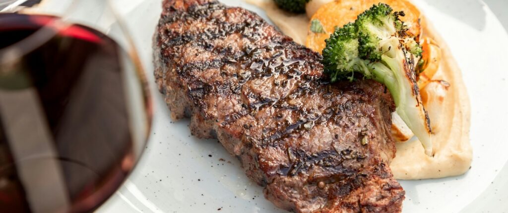 steak dinner and glass of wine at a fancy restaurant