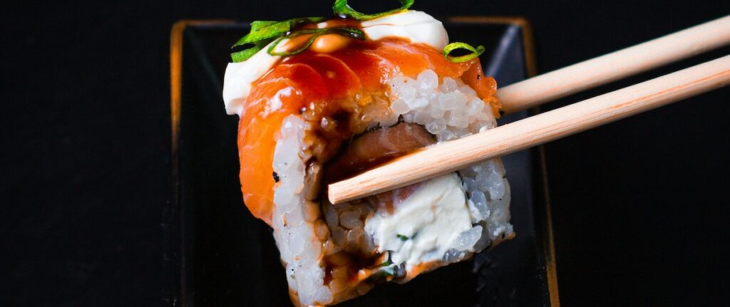 chopsticks holding sushi