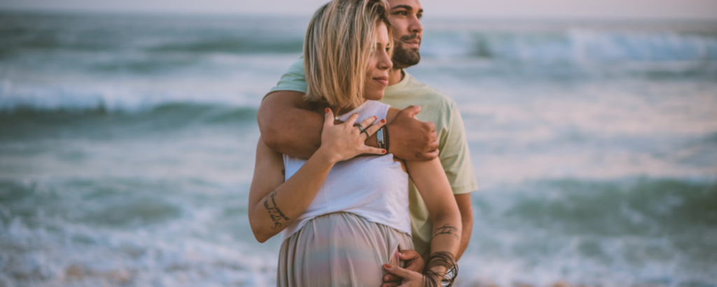 pregnant couple on beach, Amelia island baby moon