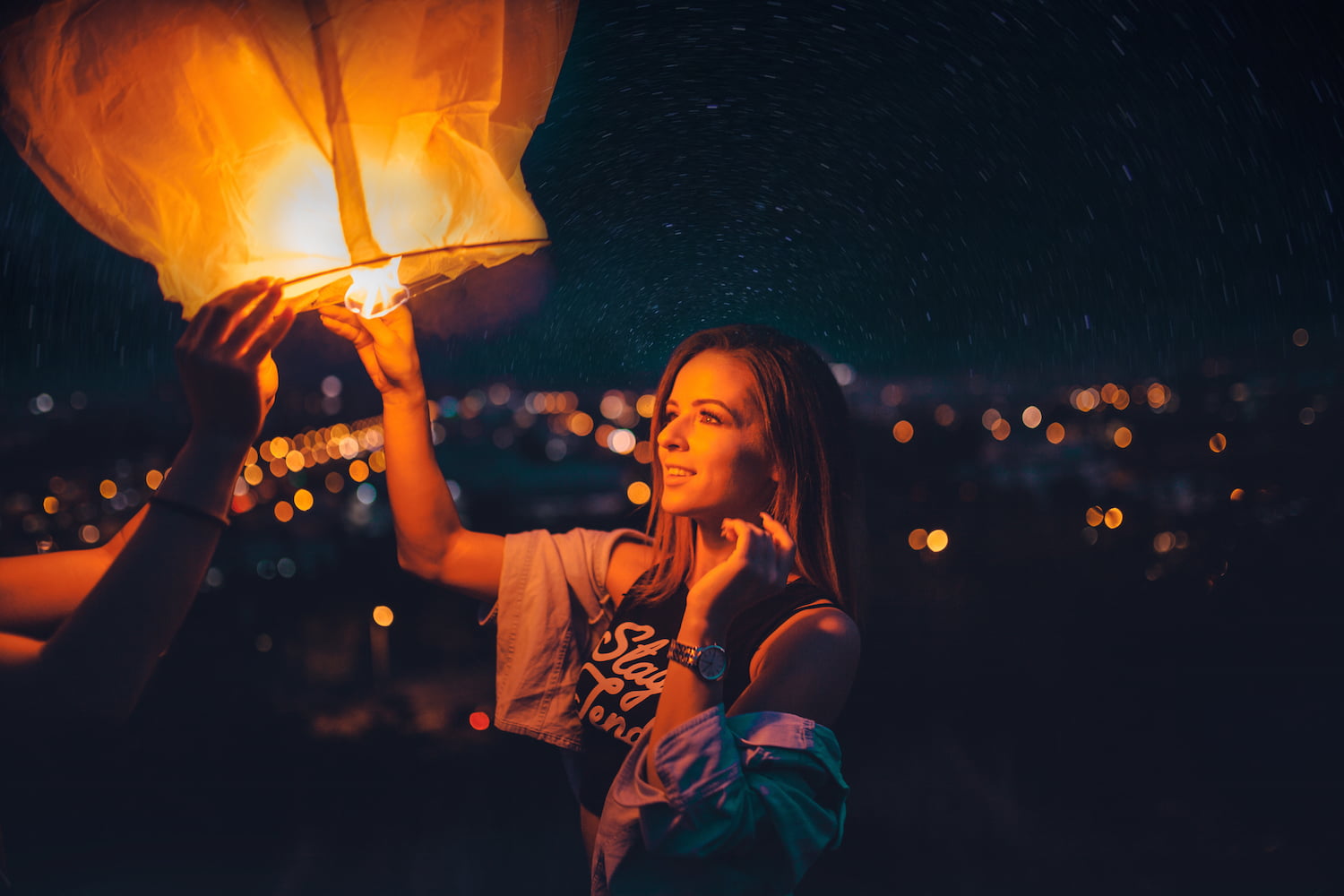 Woman lighting paper lantern.