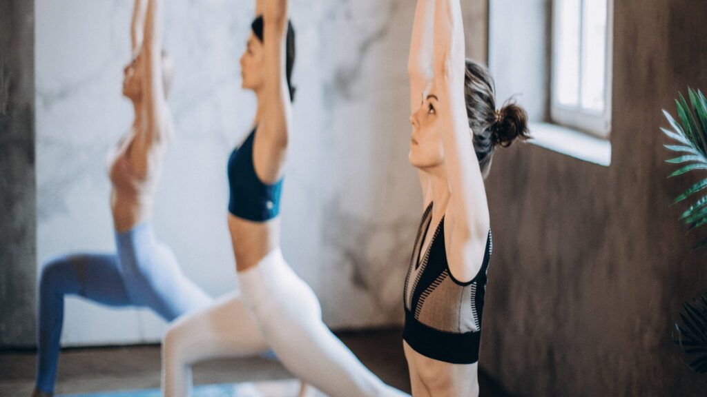 Three women doing yoga in a studio
