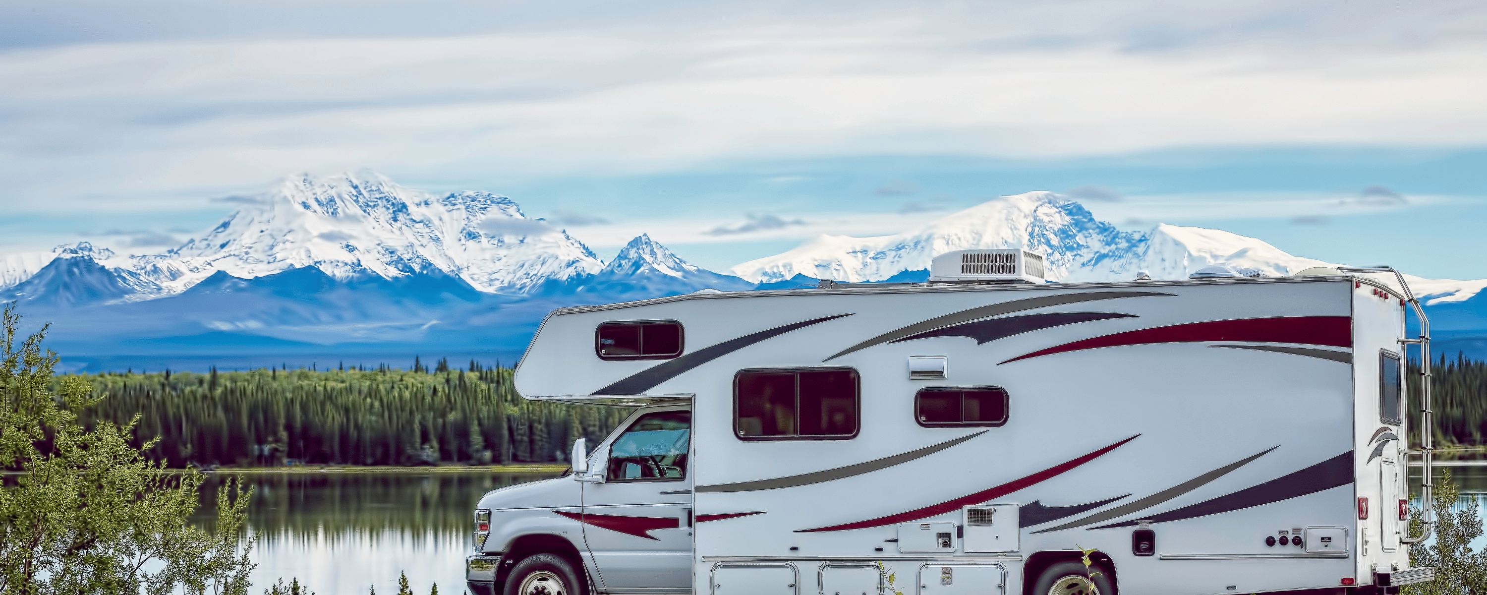 An RV parked in front of a lake in Alaska near Wrangell St. Elias National Park