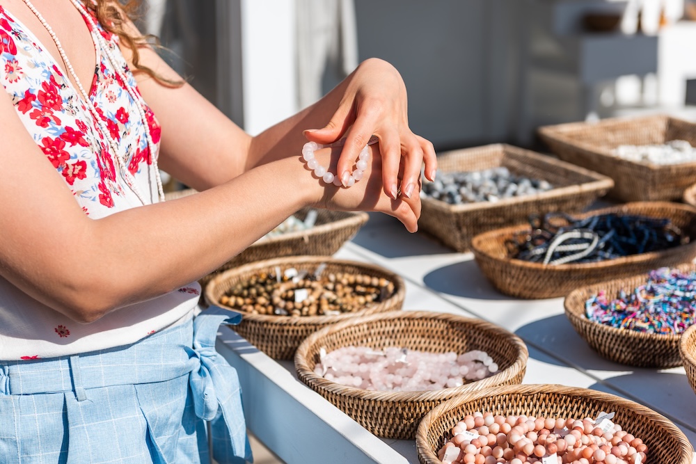 A woman viewing jewelry at a market stall